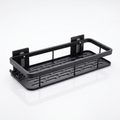 Black wall-mounted bathroom shelf with slotted base and hook bar on a white background