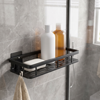 Black bathroom shelf mounted inside a shower holding bottles and soap with a washcloth on the side hook