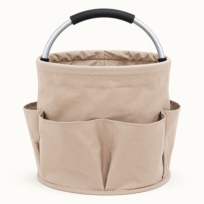 Empty beige round fabric cleaning caddy with exterior pockets and an arched aluminum handle on a light background