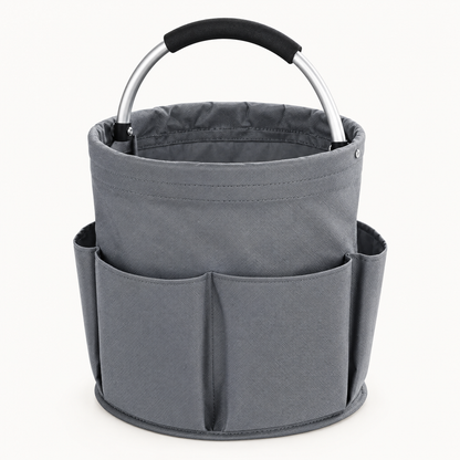 Empty grey round fabric cleaning caddy with exterior pockets and an arched aluminum handle on a light background