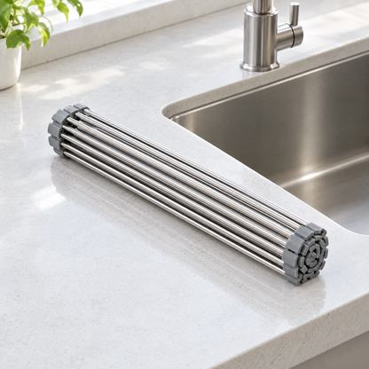 Dish drying rack rolled up into a compact cylinder on a kitchen countertop beside the sink