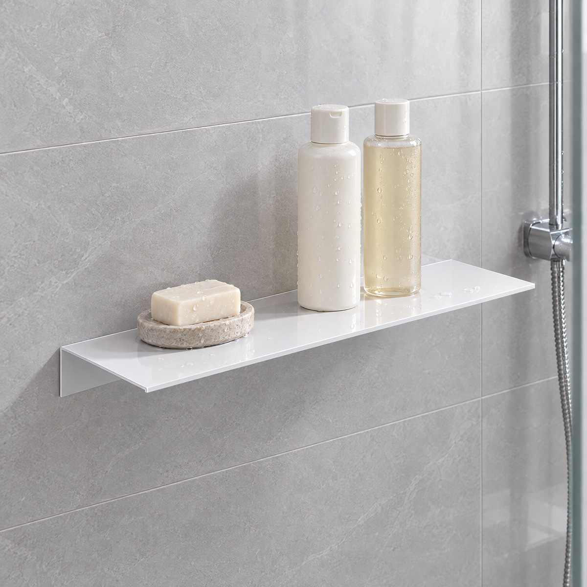 White floating shelf on grey shower tile holding shampoo bottles and a bar of soap