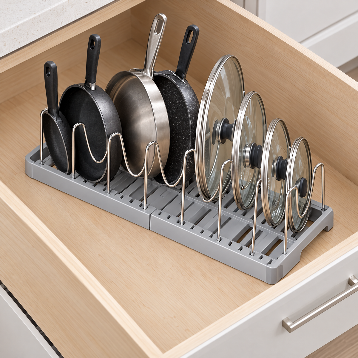 Expandable pan organizer rack inside a deep kitchen drawer with pans and lids