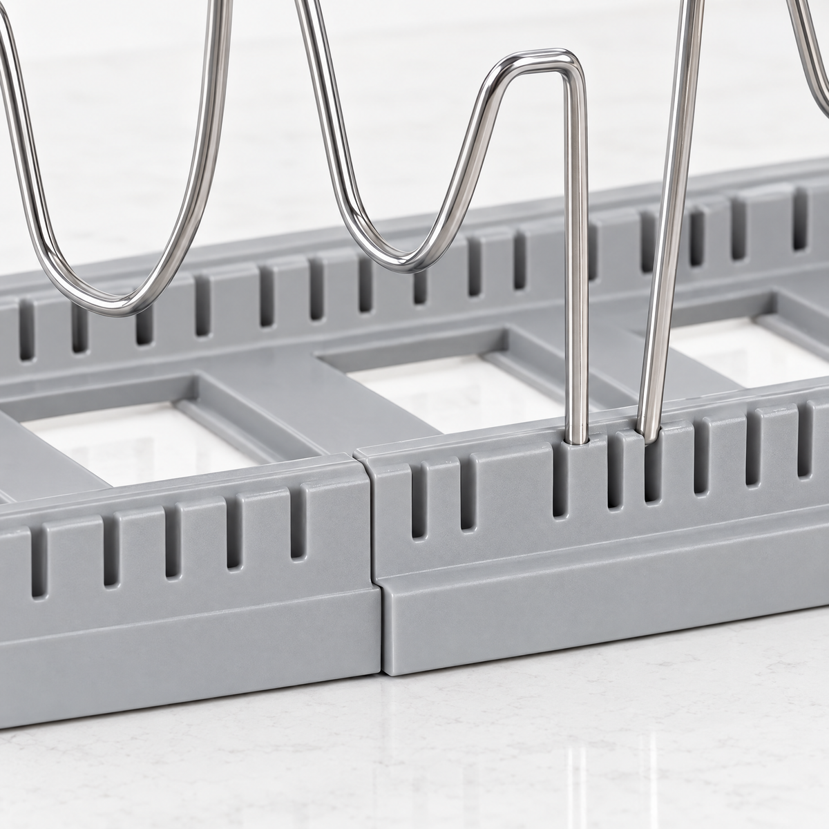 Close-up of the slotted base and adjustable wire dividers of the pot and pan organizer