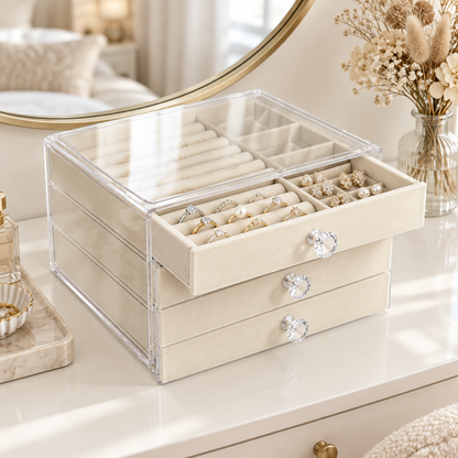 Clear 3-drawer jewelry organizer with beige velvet trays on a vanity