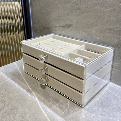 Jewelry organizer box with beige velvet trays on a counter